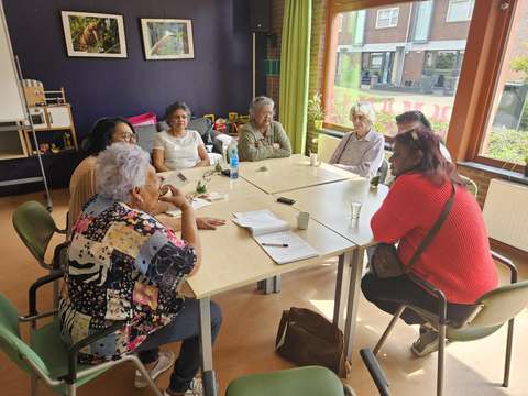 Groep aan gesprekstafel tijdens lokale bijeenkomst | Krachtig ouder worden