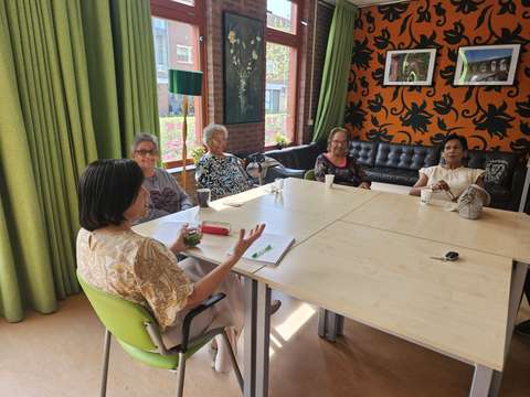 Groep aan gesprekstafel tijdens lokale bijeenkomst | Krachtig ouder worden