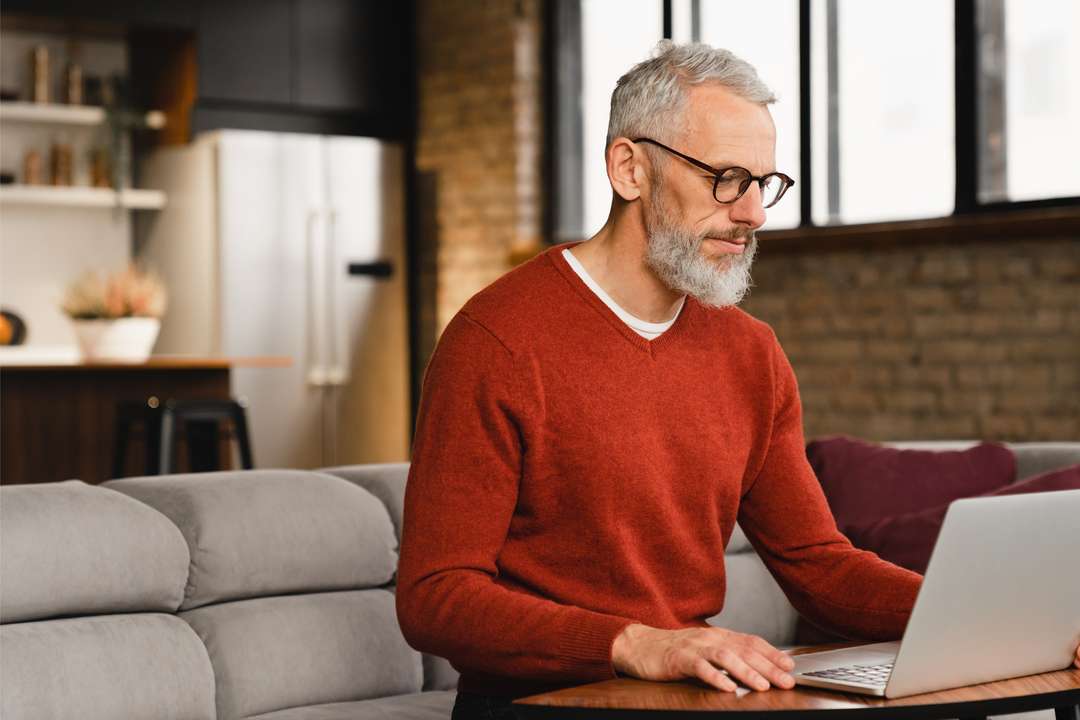 Meneer met laptop op de bank | ANBO-PCOB