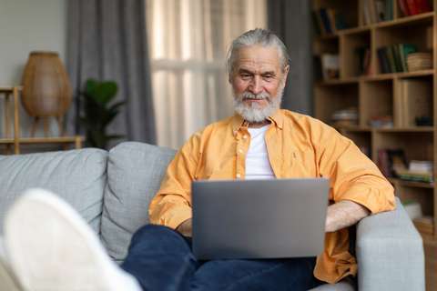 Man kijkt naar laptop op de bank | ANBO-PCOB