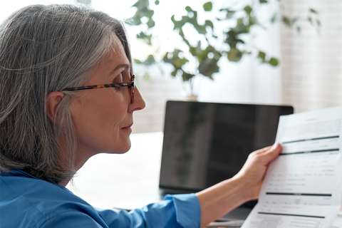 Mevrouw kijkt naar papieren | ANBO-PCOB