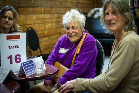 Lachende dame aan gesprekstafel | Krachtig ouder worden