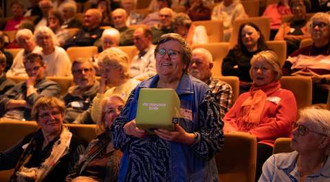Staande vrouw met catchbox in publiek | Krachtig ouder worden