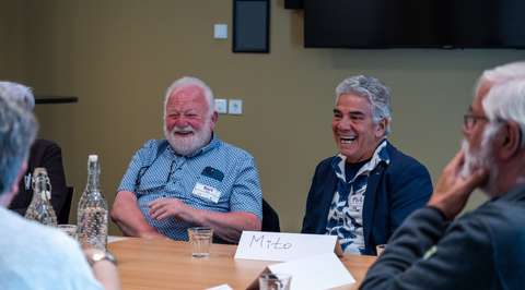 Lachende man en gespreksbegeleider aan tafel | Krachtig ouder worden