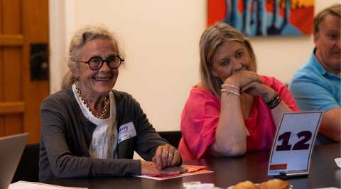 Lachende vrouw aan gesprekstafel | Krachtig ouder worden