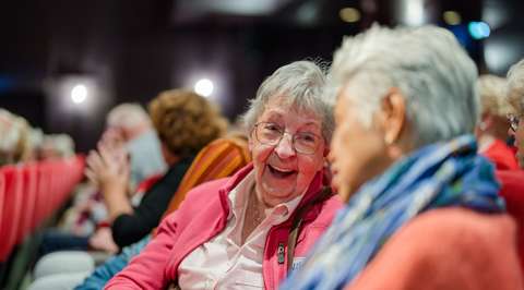 Lachende dame in publiek | Krachtig ouder worden